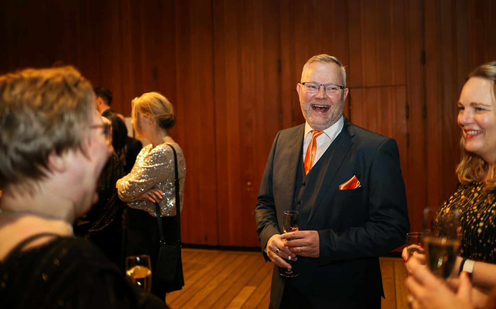 Guests laughing together at a formal evening event