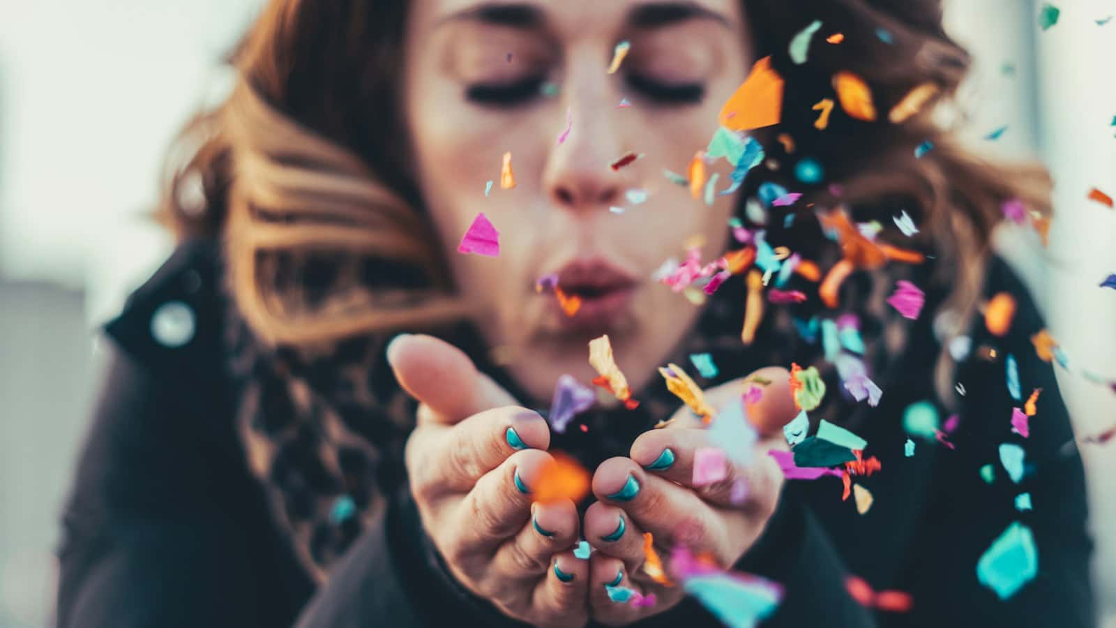 Guest blowing colourful confetti from her hands