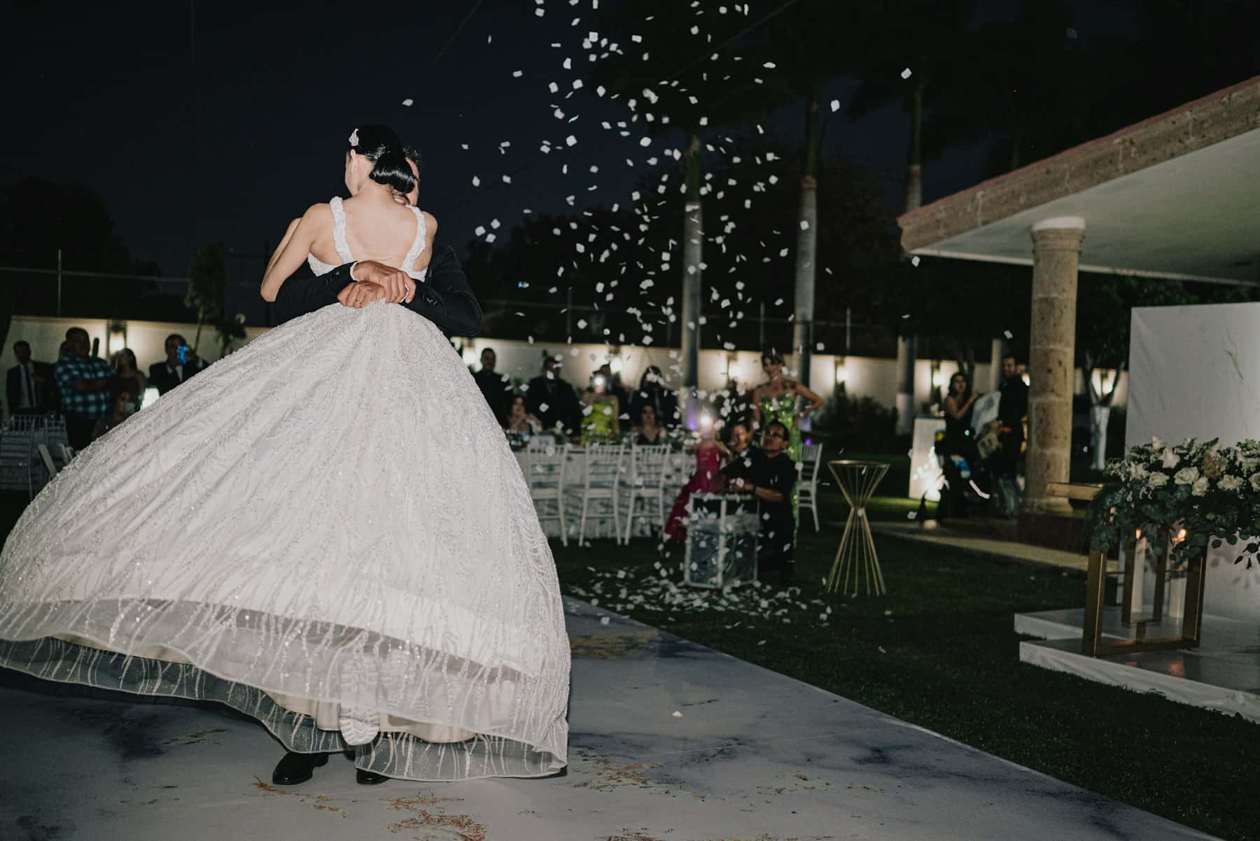 Couple dancing under falling petals at night