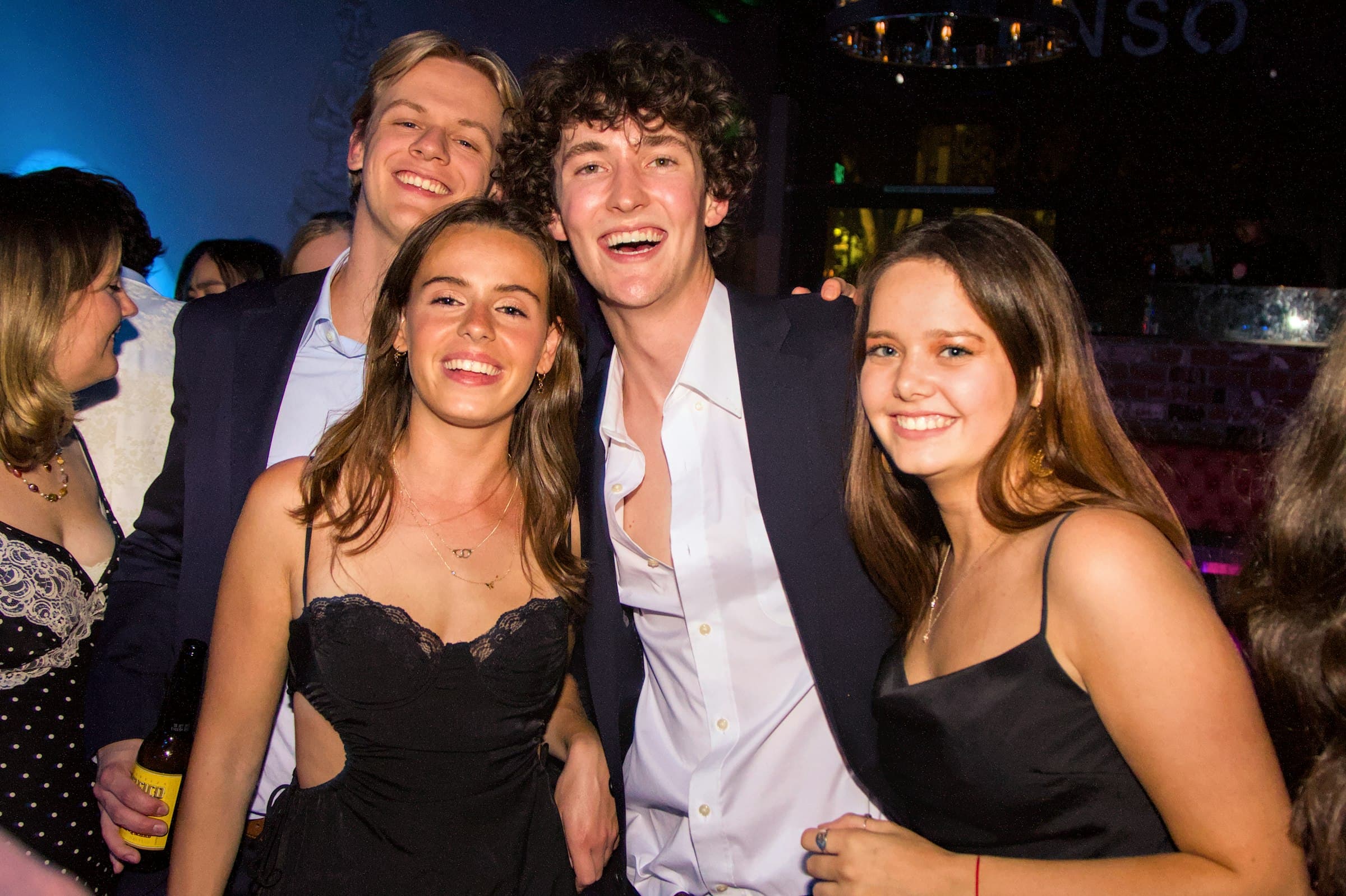 Friends smiling and posing together for the camera at an evening party